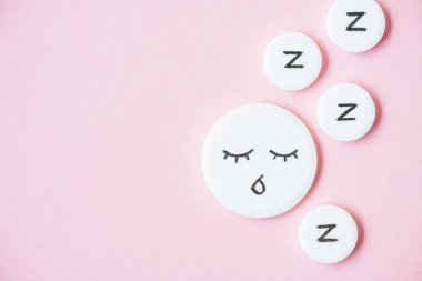 uyku hapı ile çizilmiş yüz ve Z üstten görünüm pembe üzerinde işaretler