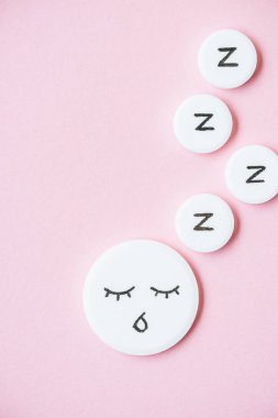 uyku hapı ile çizilmiş yüz ve Z üstten görünüm pembe üzerinde işaretler