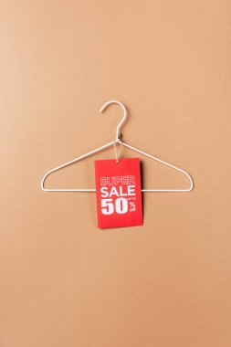 hanger with red super sale tag with fifty percents discount on beige clipart