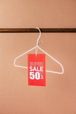 one hanger with red super sale tag - 50 percents on beige clipart