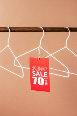 askıları kırmızı süper satış etiketiyle - 70 yüzdeleri bej üzerinde indirim.