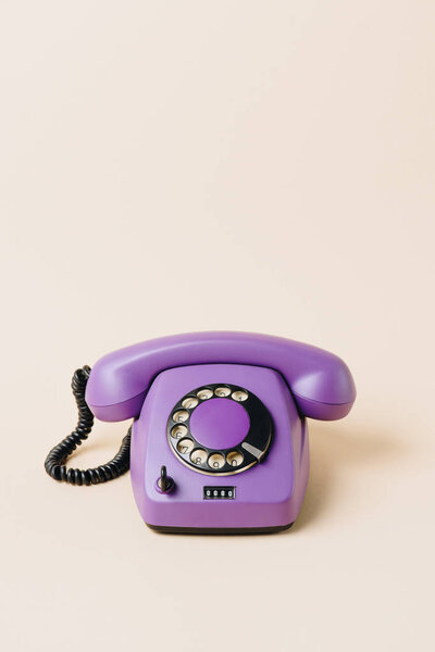 один фиолетовый винтажный телефон на бежевый
