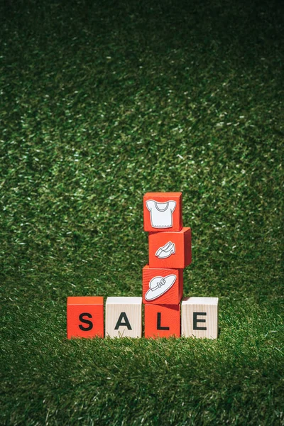 Red Wooden Alphabet Cubes Sale Sign Clothes Green Grass Black — Free Stock Photo