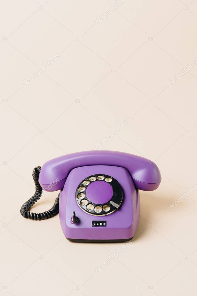 one purple vintage telephone on beige