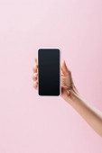abgeschnittene Aufnahme einer Frau mit Smartphone und leerem Bildschirm isoliert auf rosa
