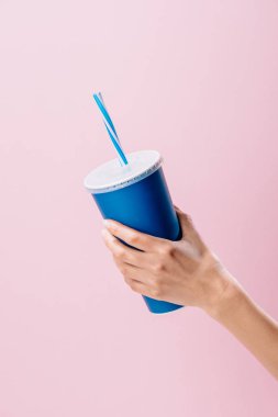 cropped shot of woman holding paper cup with drink isolated on pink clipart