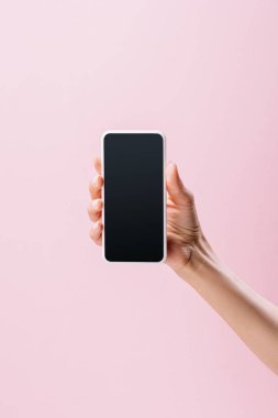 cropped shot of woman holding smartphone with blank screen isolated on pink clipart