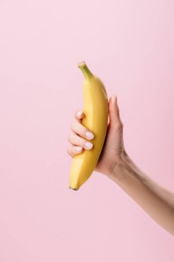 Kırpılan atış pink izole muz tutan kadın