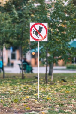 No dog poop sign on lawn in autumn park clipart