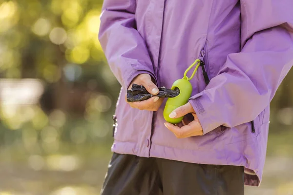 Tiro Recortado Mujer Sosteniendo Contenedor Con Bolsas Para Limpiar Después — Foto de Stock