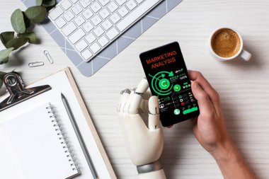 masada kahve fincanı Office ile ekranda pazarlama analizi ile smartphone kullanarak protez kollu işadamı resim kırpılmış 