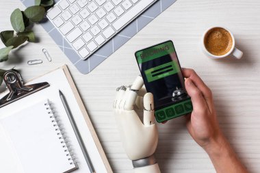 masada kahve fincanı Office ile ekranda rezervasyon ile smartphone kullanarak protez kollu işadamı resim kırpılmış