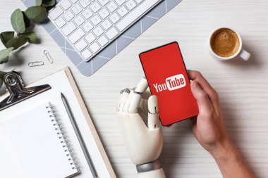 işadamı ile genç masada kahve fincanı Office ile ekranda smartphone kullanarak protez kollu kısmi görünümü 