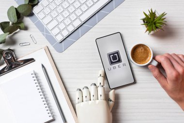 uber masada kahve fincanı Office ile ekranda ile smartphone kullanarak protez kollu işadamı resim kırpılmış 