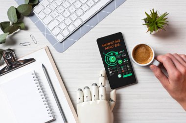 İş Analizi masada kahve fincanı Office ile ekranda pazarlama ile smartphone kullanarak protez kollu adamı kısmi görünümü 