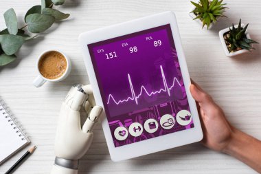 masada kahve fincanı Office ile ekranda tıbbi uygulama ile dijital tablet kullanarak cyborg el ile işadamı resim kırpılmış 