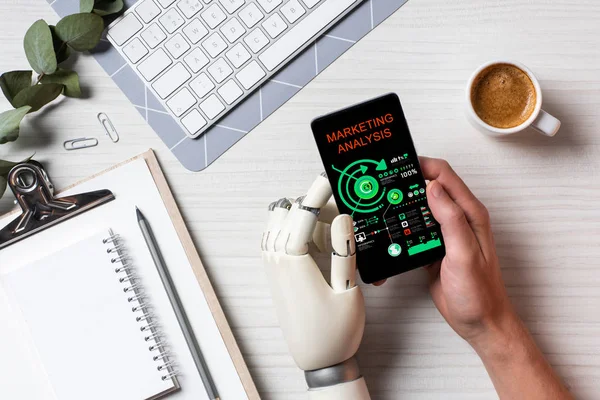 masada kahve fincanı Office ile ekranda pazarlama analizi ile smartphone kullanarak protez kollu işadamı resim kırpılmış 