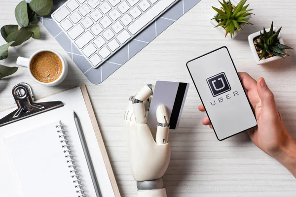 işadamı kredi kartı tutan ve uber ofiste tabloda, ekranda ile smartphone kullanarak protez kol ile kısmi görünümü 