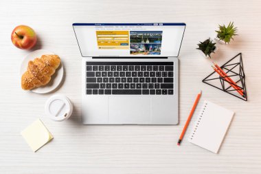 rezervasyon web sitesi, kruvasan ve kahve Ofis masaları ile dizüstü üstten görünüm   