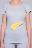 Provedena částečná zobrazení ženy s papírem slinivky na tričko na šedém pozadí