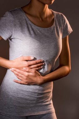 kısmi karaciğer ağrısı koyu arka plan üzerinde sahip kadın görünümünü