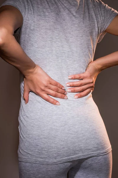 Teilbild Einer Frau Mit Rückenschmerzen Vor Dunklem Hintergrund — Stockfoto