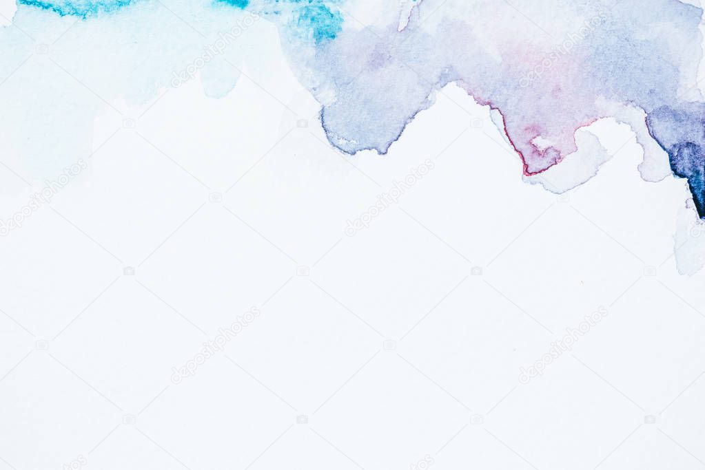 abstract blue and purple watercolor blots on white paper background with copy space