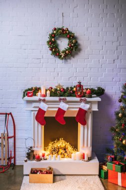 Fireplace with decorations near Christmas tree at home clipart