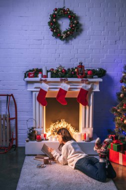 Şömine ve Noel ağacı çok güzel kadın Noel okuma dekore edilmiş