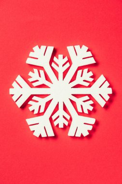 top view of paper snowflake on red background clipart