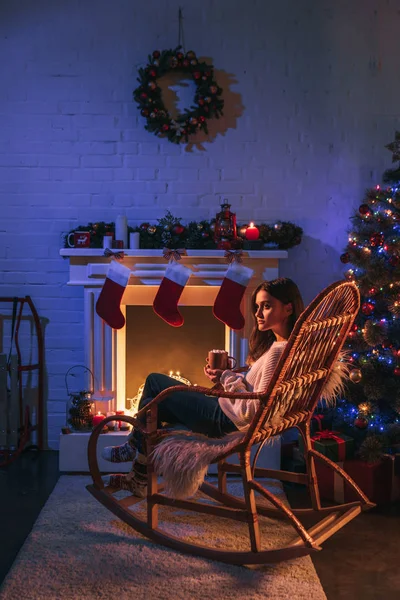 Schöne Frau Sitzt Schaukelstuhl Neben Kamin Und Weihnachtsbaum — Stockfoto