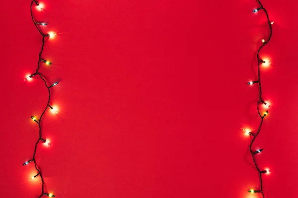 Two Glowing Garlands Red Background Copy Space — Stock Photo, Image