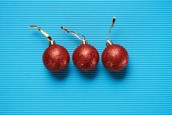 Flat Lay Three Red Shiny Decorative Christmas Balls Blue Textured — Free Stock Photo