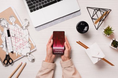 Ofis Masası smartphone ekranında, düz app pazarlama ile holding laptop ve kadın eller ile yatıyordu