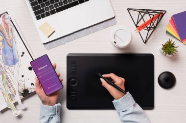Görünüm Tasarımcısı grafik tableti kullanarak kırpılmış, kalem ve smartphone ekranında, düz instagram app ile yatıyordu
