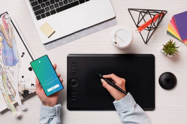 Görünüm Tasarımcısı grafik tableti kullanarak kırpılmış, kalem ve smartphone ile twitter app ekran, düz üzerinde yatıyordu