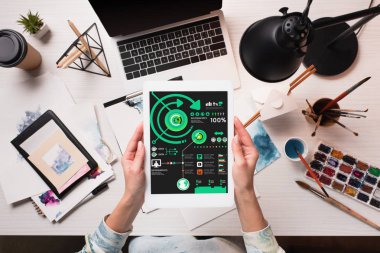 Kırpılan görünümü tasarımcısının ofis masası ile sanat malzemeleri, düz yatıyordu ekranında analiz app pazarlama ile tablet holding