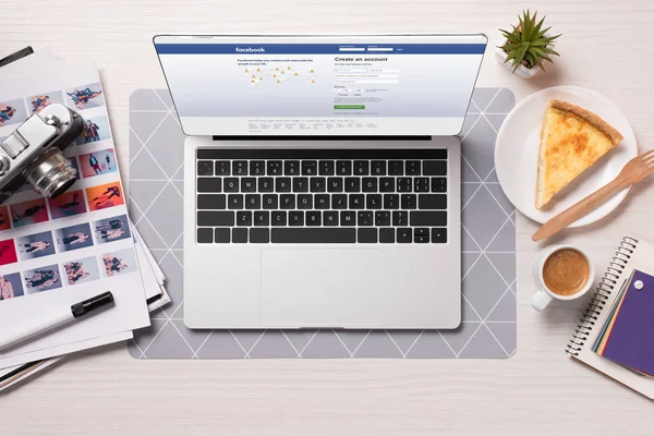 Facebook ウェブサイト画面 フラット付きのノート パソコンのオフィスの机を置く — ストック写真