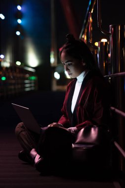 oturma ve neon ışık, gelecekteki kavramının şehir sokakta dizüstü kullanarak kimono içinde çekici Asyalı kız