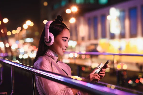 Side View Smiling Asian Girl Listening Music Smartphone Street Neon — Stock Photo, Image