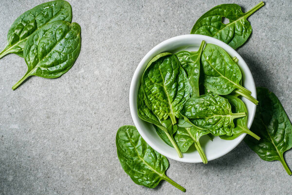 Top view of wet spinach leaves in bowl