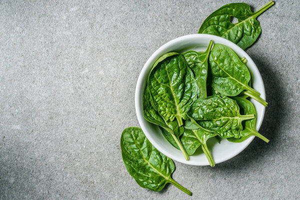 Top view of green spinach leaves in white bowl 