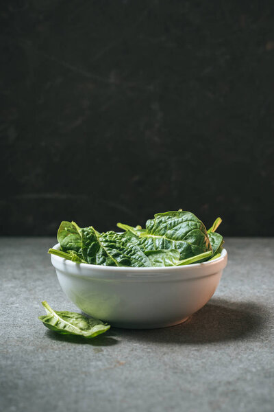 healthy spinach leaves in white bowl with copy space