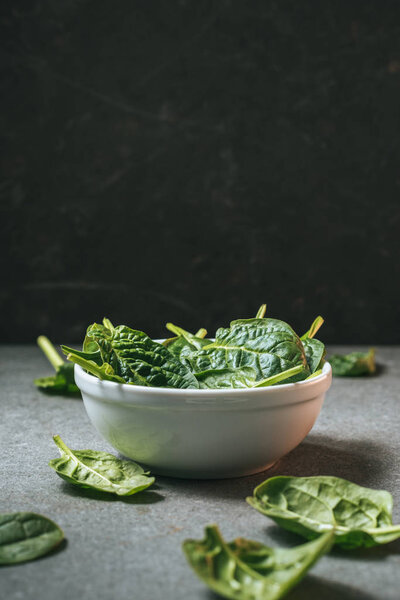 white bowl with green organic spinach with copy space