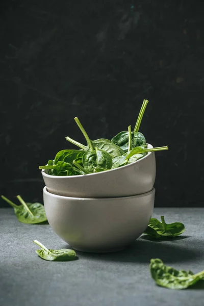 Raw organic spinach leaves in white bowls