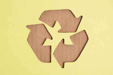 Top view of cardboard recycle sign on yellow background clipart