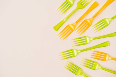 Pembe bir arka plan üzerinde renkli plastik çatal üstten görünüm