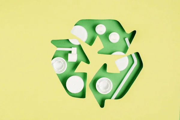 Κάτοψη Της Ανακύκλωσης Πράσινο Σημάδι Μοτίβο Καπάκια Μπουκαλιών Κίτρινο Φόντο — Φωτογραφία Αρχείου