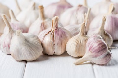 bulbs of garlic on white rustic wood table clipart