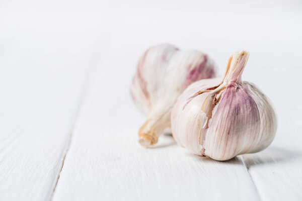 Two bulbs of ripe garlic on wooden table